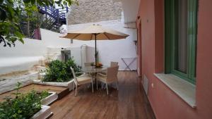 a table and chairs with an umbrella on a patio at City Break Metro Ambelokipi in Athens