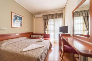 een hotelkamer met een bed en een bureau bij Lido Hotel in Kateríni