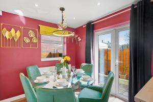 a dining room with a table and green chairs at Stunning House in Bristol - Hot Tub - Sleeps 10 in Bristol