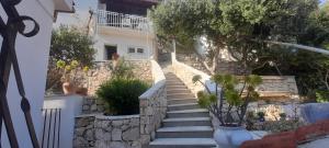 uma escada que leva a uma casa branca com árvores em Paradies Apartments Prizba em Blato