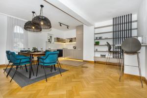 una cucina e una sala da pranzo con tavolo e sedie blu di Art of Living luxury suite a Sarajevo