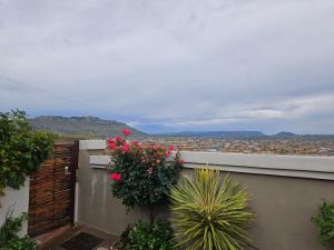 - un balcon fleuri offrant une vue sur la ville dans l'établissement Three Stones Executive Apartments, à Maseru