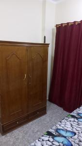 a wooden cabinet next to a red curtain at Ikea flat 5 in Hurghada