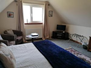 1 dormitorio con 1 cama, TV y ventana en Balmoral Skye, en Portree