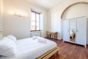 sypialnia z dużym białym łóżkiem i stołem w obiekcie [Duomo] Elegante Appartamento we Florencji