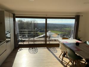 a kitchen and dining room with a view of a balcony at The Green Escape in Merlemont +22 photos