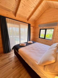 a large bed in a wooden room with a window at KARYA TREE HOUSE in Dalaman