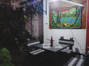 a patio with a table and a painting on the wall at SK HOUSE RESORT UNAWATUNA in Unawatuna