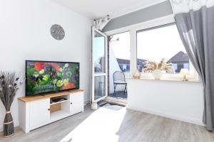 a living room with a tv and a large window at Ferienwohnung Stern in Bensersiel