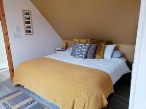 a bedroom with a bed with a yellow blanket at "Balmoral View" in Ollach