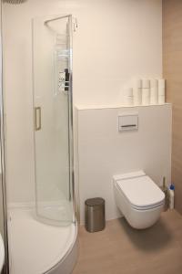 a white bathroom with a toilet and a shower at Studio Apartment in the Heart of Riga Old Town in Rīga