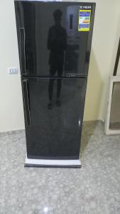 a black refrigerator with a picture of a person on it at Ikea flat 4 in Hurghada