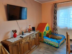 Casa Aurici Vatra Dornei في فاترا دورني: غرفة أطفال مع سرير أطفال وبيت ألعاب