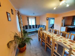 a dining room and living room with a table and chairs at Casa Aurici Vatra Dornei in Vatra Dornei
