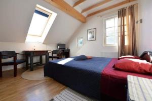 a bedroom with a bed and a table and window at Vecekrug Apartaments in Preila