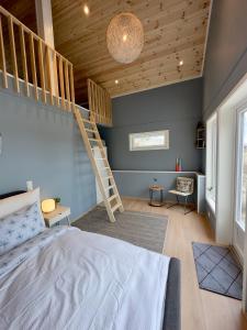 a bedroom with a bed and a staircase in it at Cozy cottage close to idyllic archipelago with additional building if booked for more than 2 people in Eydehamn