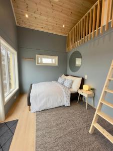 Un dormitorio con una cama y una escalera. en Cozy cottage close to idyllic archipelago with additional building if booked for more than 2 people, en Eydehamn