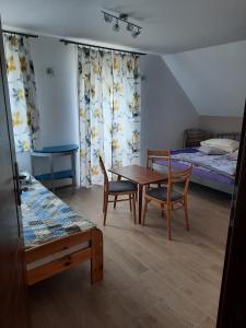 um quarto com uma mesa e cadeiras e uma cama em Agroturystyka Patynówka em Kletno