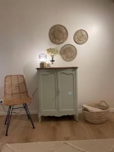 zieloną szafkę i krzesło w pokoju w obiekcie L'escapade w mieście Milly-la-Forêt