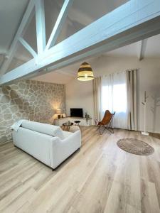 sala de estar con sofá blanco y mesa en L'escapade, en Milly-la-Forêt