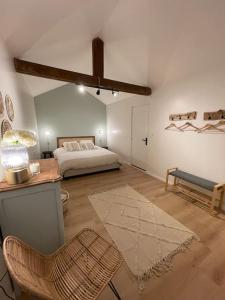 1 dormitorio con 1 cama, 1 mesa y 1 silla en L'escapade, en Milly-la-Forêt