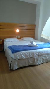 Habitación de hotel con cama grande y cabecero en Wafeh Flats em San Diego Lourdes, en Belo Horizonte