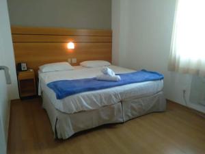 um quarto com uma cama com um bicho de peluche em Wafeh Flats em San Diego Lourdes em Belo Horizonte
