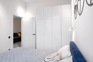 een witte slaapkamer met een bed en een spiegel bij VICTORY luxury in Lviv