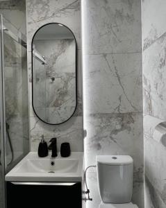 La salle de bains est pourvue d'un lavabo, d'un miroir et de toilettes. dans l'établissement Mirovski Apartment, à Varsovie
