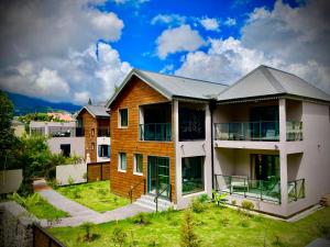 une maison avec une pelouse verte devant elle dans l'établissement La Villa Kazuera, à Cilaos