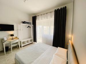 1 dormitorio con cama, escritorio y ventana en Leone Suite B&B & Restaurant, en Palermo