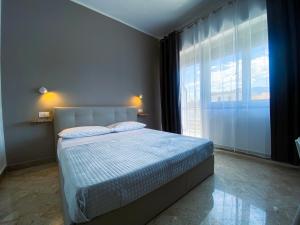 1 dormitorio con cama y ventana grande en Leone Suite B&B & Restaurant, en Palermo