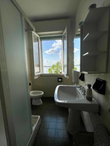 bagno con lavandino, servizi igienici e finestra di B&B Casanonni Borgo Angeli a Mantova