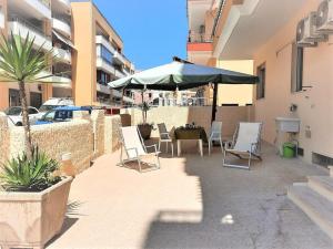 un patio con tavolo, ombrellone e sedie di Gallipoli - Lido S. Giovanni - 200 meters from the sea a Gallipoli