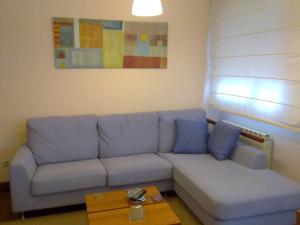 sala de estar con sofá azul y mesa en Piso acogedor con Parking, en Vigo