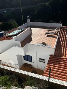 a white house with a red roof and stairs at Casa a pequena sereia in Benagil with sea view in Carvoeiro