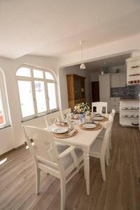 Biały stół i krzesła w kuchni w obiekcie Casa a pequena sereia in Benagil with sea view w mieście Carvoeiro