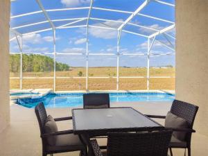 a patio with a table and chairs and a swimming pool at 4 Bed 428 in Davenport