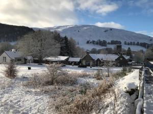 a snow covered village with houses and a mountain at Dalgreine Guest House in Blair Atholl