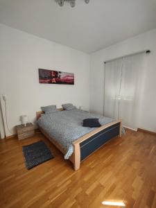 Schlafzimmer mit einem Bett und Holzboden in der Unterkunft Casa le palme -Montagnola in Collina d'Oro