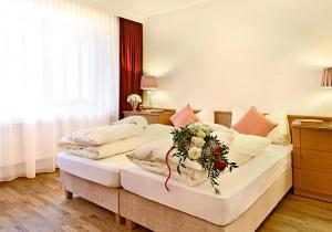 a bedroom with a large bed with a flower arrangement on it at Alpen Lodge in Sankt Anton am Arlberg