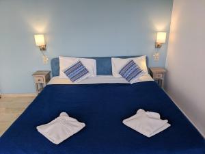 Un dormitorio con una cama azul con toallas. en Coral, en Frangokastello
