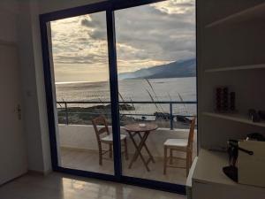 a view of the ocean from a balcony with a table and chairs at Coral in Frangokastello