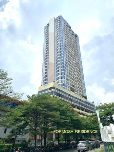 ein hohes Gebäude mit einem Schild davor in der Unterkunft Apartemen Formosa Residence Nagoya Batam by Wiwi in Nagoya