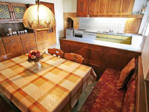 a kitchen with a table and a kitchen with a stove at Chalet Sternberg in Strengen