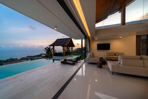 a living room with a view of the ocean at Samui Privacy Modern Luxury Seaview Natural Rainforest Infinity Pool Villa in Koh Samui 