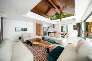 uma sala de estar com mobiliário branco e uma mesa em Samui Privacy Modern Luxury Seaview Natural Rainforest Infinity Pool Villa em Koh Samui