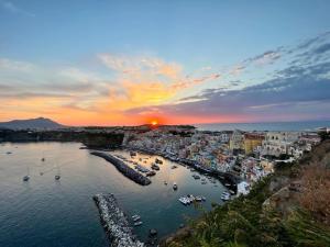 a sunset over a harbor with boats in the water at Casetta Giulia in Procida