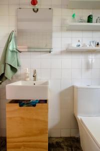 Baño blanco con lavabo y espejo en El apartamentito de Casa del Abuelo, en Isla Canela