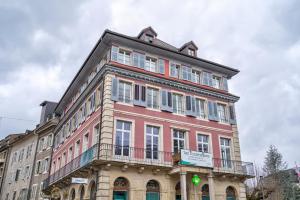 a large red building with a balcony at The 5 Continents II by Stay Swiss in Porrentruy